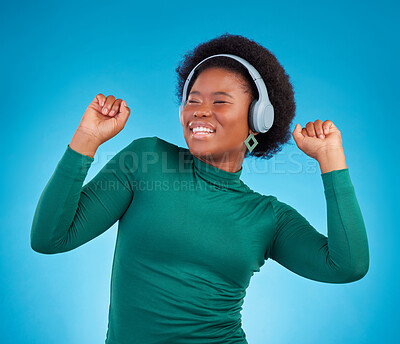 Buy stock photo Dance, music and headphones with black woman in studio for streaming, audio and relax. Online radio, technology and listening with female isolated on blue background for hip hop and movement