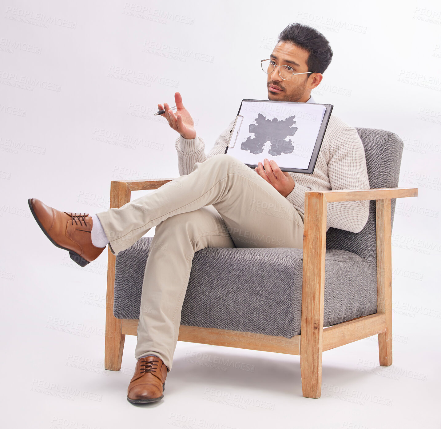 Buy stock photo Psychology, psychologist and man with rorschach test diagram on clipboard in studio isolated on a gray background. Therapist, consultant and male sitting on chair with document for inkblot exam.