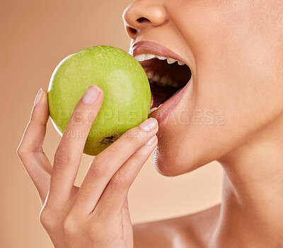 Buy stock photo Apple, dental or mouth of woman eating in studio on beige background for healthy nutrition or clean diet. Bite, hand or zoom of hungry girl advertising or marketing natural green fruits for wellness 