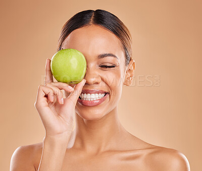 Buy stock photo Beauty, skincare or happy woman with apple in studio on beige background for healthy nutrition or clean diet. Smile, face or girl model laughing or marketing natural fruits for vitamins or wellness 