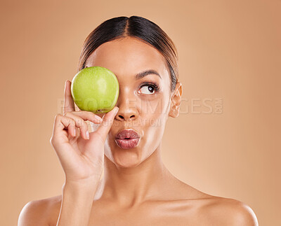 Buy stock photo Beauty, skincare or woman with apple in studio on beige background for healthy nutrition or clean diet. Eye, hand or girl model advertising or marketing natural fruits for nutrition or wellness 
