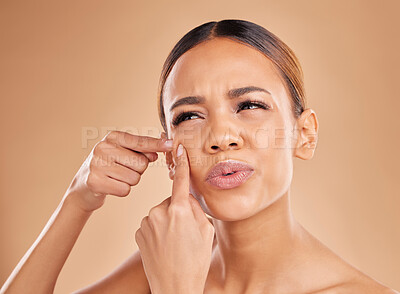 Buy stock photo Skincare, pop pimple and woman in a studio with a natural, beauty and cosmetic face routine. Cosmetics, wellness and female model from Mexico squeezing a zit, acne or blemish by a brown background.