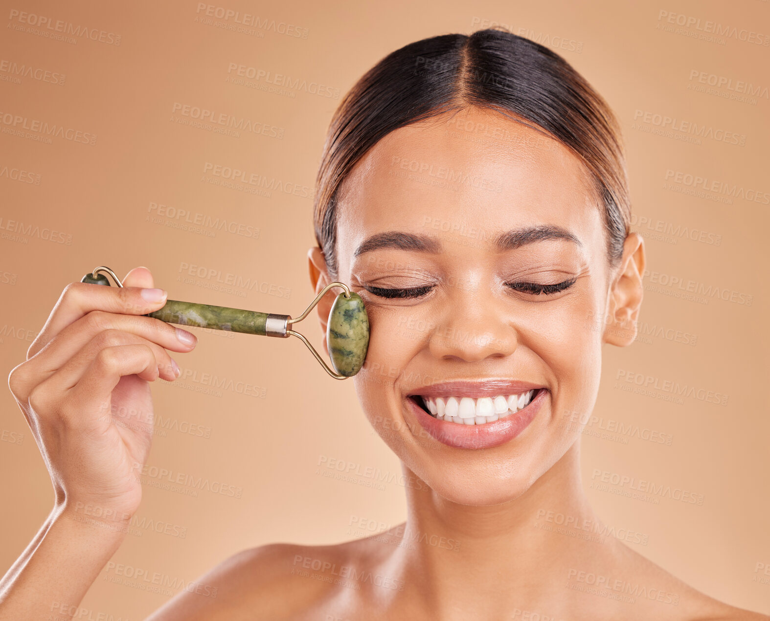 Buy stock photo Happy woman, beauty or face massage with roller, facial product for healthy skincare on studio background. Smile, crystal stone treatment or girl model with dermatology cosmetics or jade marketing