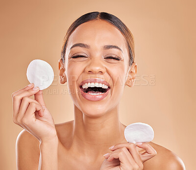 Buy stock photo Face, funny and woman with cotton pad, skincare and happiness against a brown studio background. Portrait female and lady laughing, makeup remover and foundation with smile, dermatology and grooming