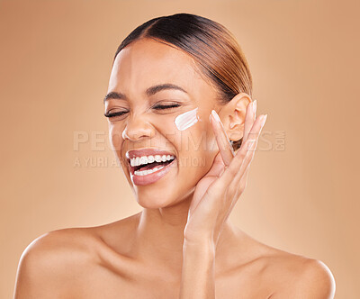 Face skincare, funny and woman with cream in studio isolated on a brown background. Laughing, beauty cosmetics and happy female model apply lotion, creme or facial moisturizer product for skin health