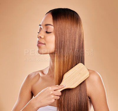 Buy stock photo Brushing hair, beauty and woman with growth and shine for healthy texture on a brown background. Face of aesthetic female in studio with a brush for natural salon keratin treatment haircare results