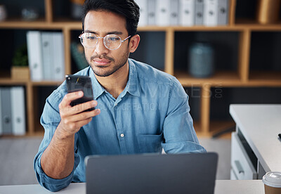 Buy stock photo Phone, serious and businessman texting on mobile app in company office as internet or online communication. Laptop, cellphone and man employee startup entrepreneur networking or searching the web