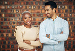 Young, professional team and partnership, teamwork with smile and arms crossed on wall background. Happy working together, creative pair and diversity, black woman and man, collaboration and trust