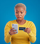 Credit card, phone and worried woman online shopping mistake, transaction fail or debt isolated on blue background. Stress, anxiety and confused person fintech payment, hacking or phishing in studio