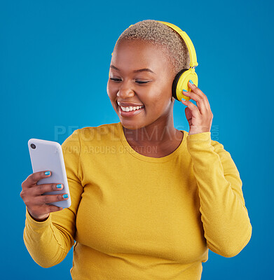 Buy stock photo Search, phone and music with black woman in studio for streaming, multimedia and browsing. Gen z, smile and audio with female and headphones on blue background for listening, online radio and songs