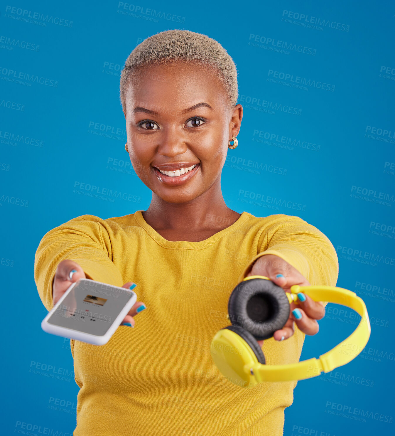 Buy stock photo Music, sharing and phone with portrait of black woman in studio for streaming, giving and multimedia for you. Podcast, mobile radio and technology with female on blue background for headphones audio