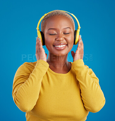 Buy stock photo Black woman, face and headphones, listening to music with rhythm and fun with freedom on blue background. Happy female with smile, streaming radio or podcast with peace and eyes closed in studio