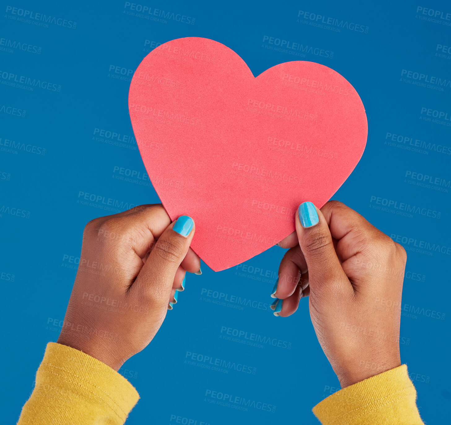 Buy stock photo Paper, heart and hands of black woman in studio for love, date and kindness. Invitation, romance and feelings with female and shape isolated on blue background for emotion, support and affectionate
