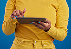 Hands, tablet and search with a woman on a blue background in studio for research on the internet. Social media, tech and 5g with a female user reading data or information online for connectivity