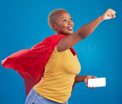 Buy stock photo Superhero, mockup and phone with black woman in studio for flying, power and deal. Mobile, strong and communication with female in red cape costume on blue background for technology, digital and 5g