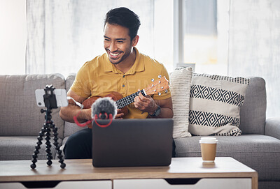 Buy stock photo Guitar, streaming and phone with a man talking online to coach during live lesson. Asian male influencer happy on home sofa with a ukulele as content creator teaching music on education podcast blog