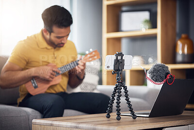 Buy stock photo Streaming, ukulele and phone with a man online to coach during live lesson. Asian male person on home sofa with a guitar as content creator or influencer teaching music on education podcast blog