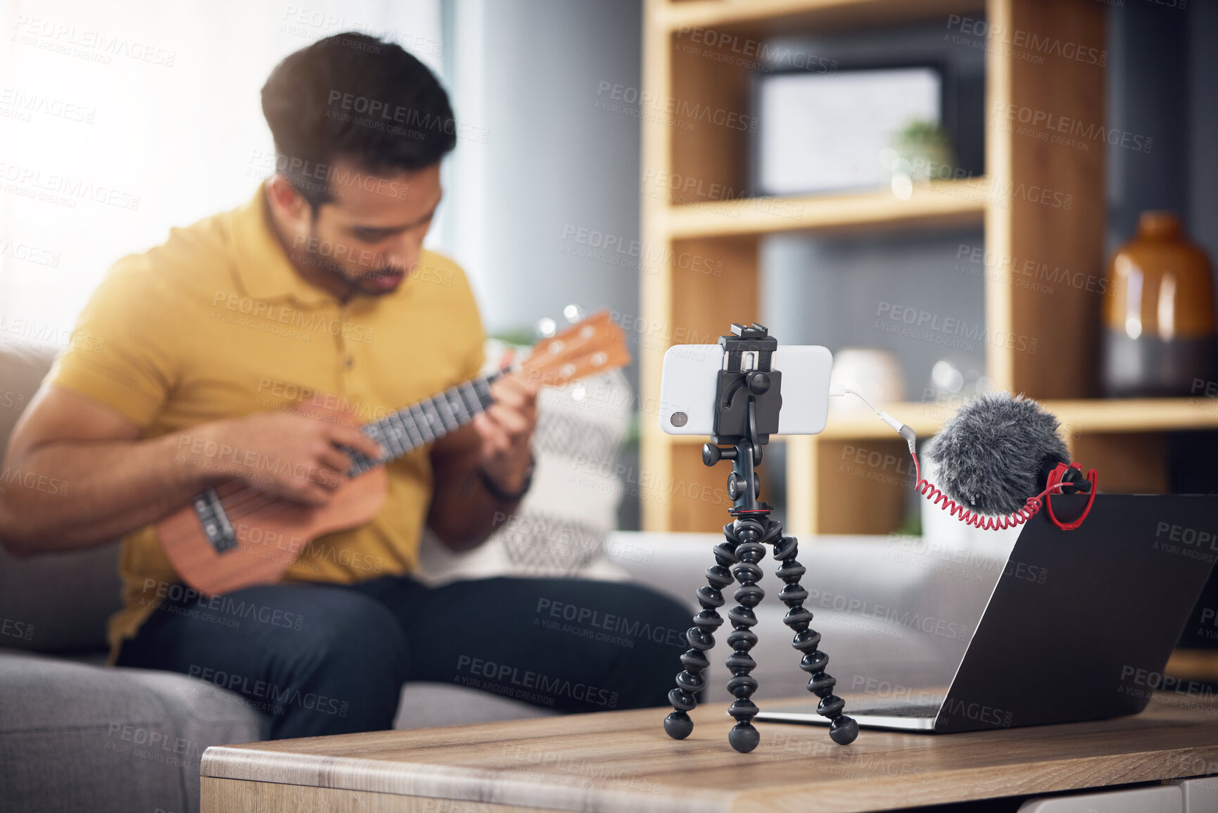 Buy stock photo Streaming, ukulele and phone with a man online to coach during live lesson. Asian male person on home sofa with a guitar as content creator or influencer teaching music on education podcast blog