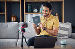 Bible study, smile and man with phone and microphone online live streaming. Asian male on home sofa with Christian religion book as blog or podcast content creator or influencer teaching or studying 