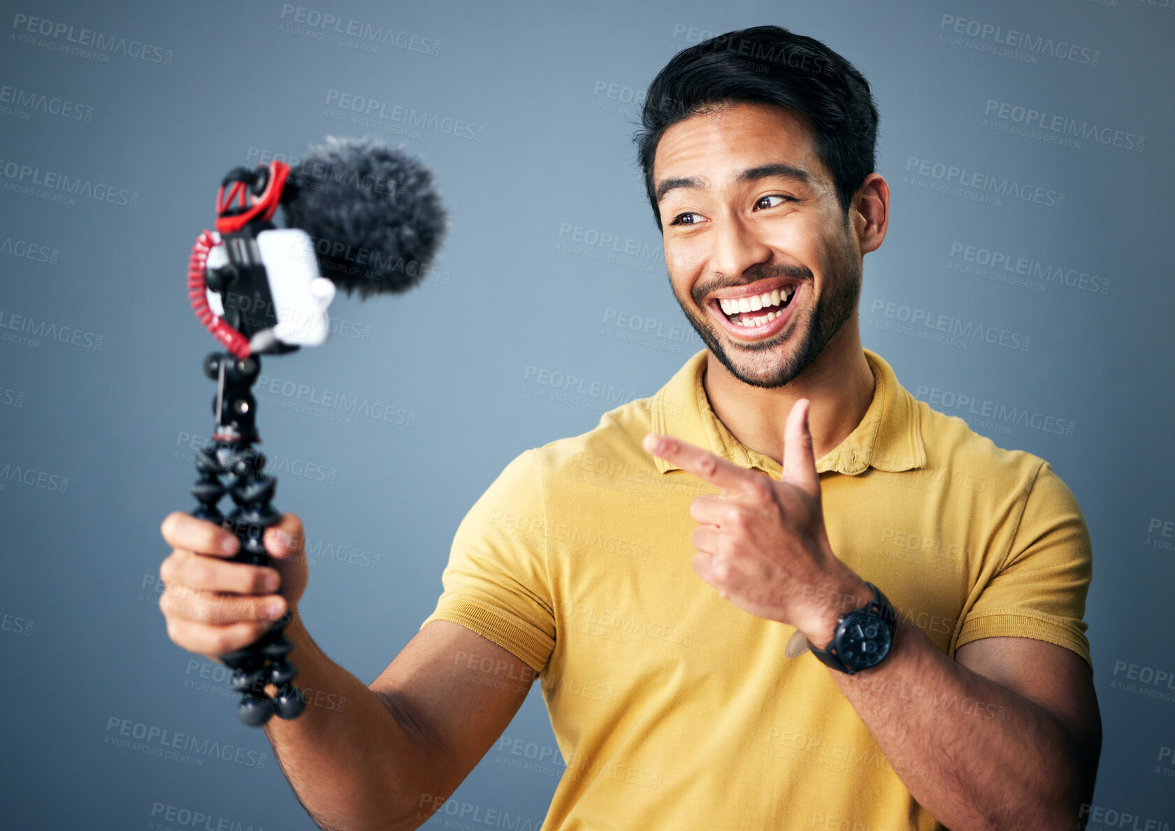Buy stock photo Phone, content creation and Indian man in studio with smile, webinar recording and live streaming on grey background. Internet, webcam and happy online influencer with smile on social media channel.