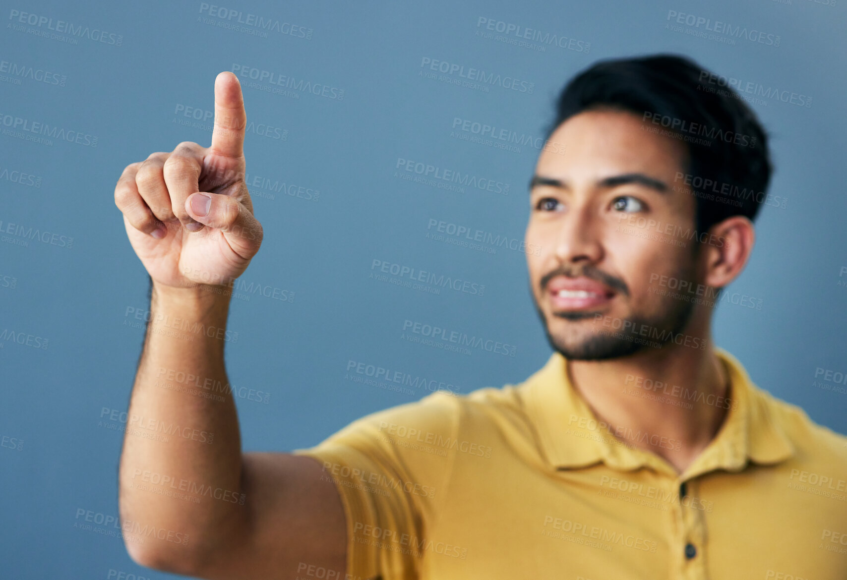 Buy stock photo Finger, pointing and asian man with invisible hologram in studio with mockup against blue background. Interface, hand and creative male entrepreneur with advertising, marketing or idea while isolated