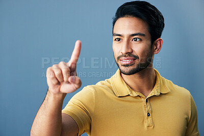 Buy stock photo Pointing, finger and asian man with invisible hologram in studio with mockup against blue background. Interface, hand and creative male entrepreneur with advertising, marketing or idea while isolated