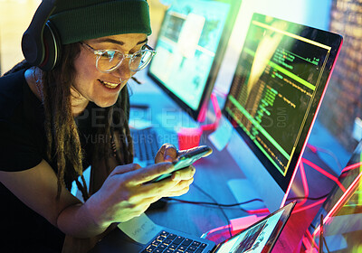 Buy stock photo Woman, phone texting and computer programmer in home for streaming radio or podcast in neon. Hacker, music headphones or happy female coder with mobile for sound, audio or typing on dark web at night