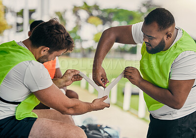 Buy stock photo Men, cutting bandage or rugby team on fitness break, exercise workout or training in a sports game. Preparation, friends or group of people in practice match with tape, strap or wrap on stadium bench