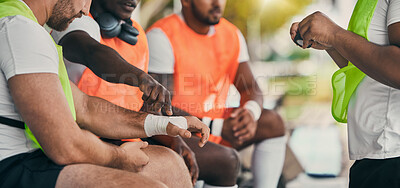 Buy stock photo Injury, sports and a man with a bandage at rugby, wrapping wrist and accident at a game. Team, playing and men protecting a hand of a player after a broken bone during sport competition or match