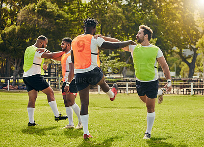 Buy stock photo Sports, rugby men and training outdoor on grass field with team stretching legs as warm up. Male athlete group together for fitness, exercise and workout for sport with support and club teamwork
