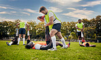 Sports, rugby and outdoor stretching legs on a grass field with a team doing warm up. Athlete men group together for fitness, exercise and workout for professional sport with coach and teamwork