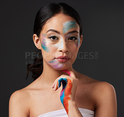 Buy stock photo Beauty, portrait and woman with paint art on hand and face in studio. Creative skin and rainbow makeup on serious female aesthetic model on gray background for lgbtq color inspiration on hands