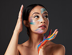 Beauty, art and woman with paint on face and hands, creative makeup and self expression. Aesthetic, creativity and artistic color cosmetics, skincare and freedom to express for young beautiful girl.