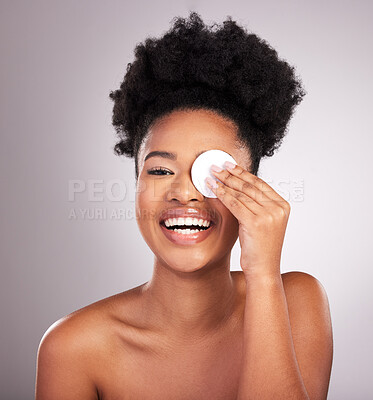 Buy stock photo Black woman, skincare and cotton on eye in studio with cleaning, makeup removal or laugh by background. Young model, wipe and clean skin for natural glow, comic smile or cosmetic health for self care