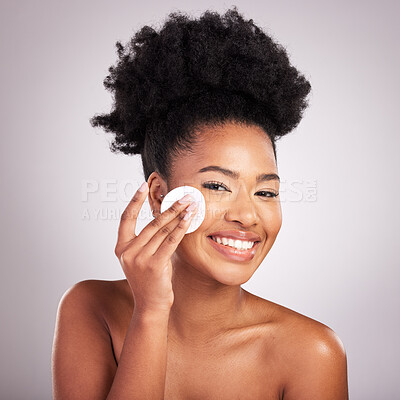 Buy stock photo Black woman, cotton pad and skincare in studio with cleaning, makeup removal and happy by background. Young model, wipe and clean face for natural glow, wellness and cosmetic health with self care