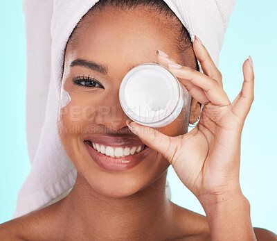 Buy stock photo Black woman, jar and cream in studio portrait with smile for skincare, wellness or self care by blue background. Girl, african and model with product by eye for natural skin glow, beauty or cosmetics