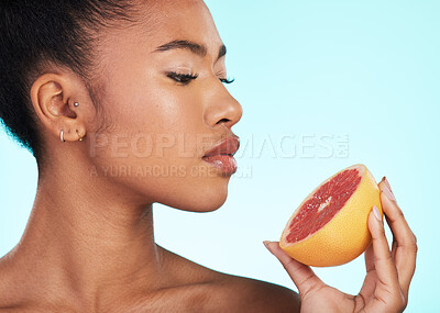Buy stock photo Grapefruit, woman and profile of a young model with skincare, fruit and wellness for diet. Isolated, blue background and studio with a person with beauty, cosmetics and healthy food for skin glow