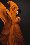 Black woman, wind and art in fashion, fabric on dark background and motion in aesthetic movement. Flowing silk, fantasy and artistic beauty, sensual African model in creative designer dress in studio