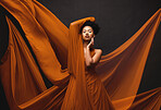Black woman, art and fashion, flowing fabric on dark background with beauty and aesthetic movement. Silk, fantasy and artistic portrait of serious African model in creative designer dress in studio.