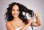 Portrait, happy woman and hair straightener for beauty in studio, treatment and wellness on background. Female model, haircare and heat styling equipment for ironing curly hairstyle, texture or tools