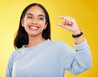 Buy stock photo Hand gesture, pinch and measure with a woman on a yellow background in studio to show a size. Smile, review and icon or symbol with an attractive young female posing on a color wall for growth