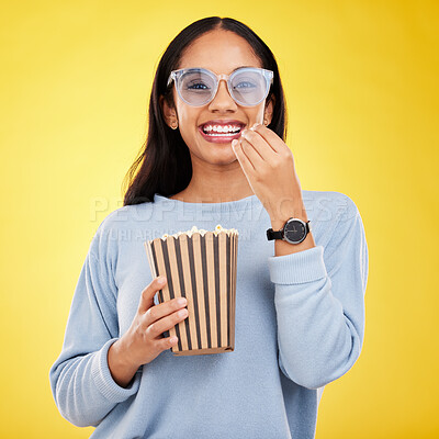 Buy stock photo Woman is eating popcorn, watching tv and happy in portrait with snack for movie on yellow studio background. Streaming service, cinema and food with corn treat, female smile with funky sunglasses 