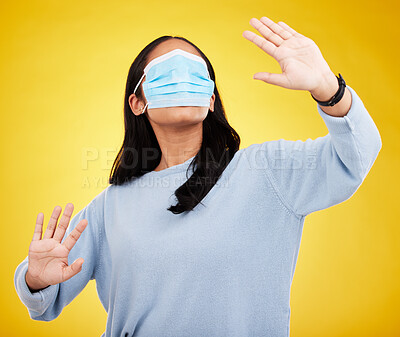 Buy stock photo Face mask, covid and woman in blindfold in studio for medical misinformation or conspiracy theory. Deception, virus and female isolated on yellow background for vaccine, protection or pandemic safety