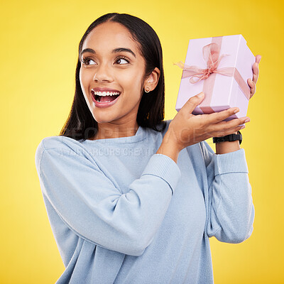 Buy stock photo Happy woman, excited and gift box in a studio with a smile from surprise present for birthday. Giveaway prize, isolated and yellow background of a young female student feeling positive and cheerful