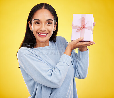Buy stock photo Woman smile, portrait and gift box in a studio happy from surprise present for birthday. Giveaway prize, isolated and yellow background of a young female student feeling positive and cheerful
