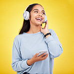 Happy, music and phone with woman in studio for streaming, online radio and audio. Smile, media and podcast with female and headphones on yellow background for technology, listening and connection