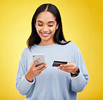 Woman with smartphone, credit card and ecommerce with smile and online shopping on yellow studio background. Fintech, online payment and bank app with happy female, checkout and internet banking