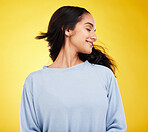 Young woman, hair and beauty, smile and satisfaction with gen z, fashion on yellow studio background. Happiness, youth and Indian female is happy with haircare and cosmetics with growth and shine