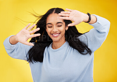Buy stock photo Happy, wind and face of woman with hands on yellow background with smile, happiness and freedom. Hair blowing, mockup space and isolated girl with open palms for beauty, relaxing and calm in studio