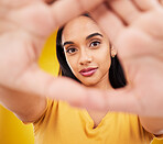 Hands, frame and portrait of a woman with perspective isolated on a yellow background in a studio. Looking, creative and a girl with focus on face, shape and showing creativity on a backdrop
